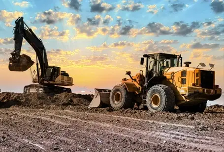 Excavator and wheel loader on a construction site secured with heavy equipment financing