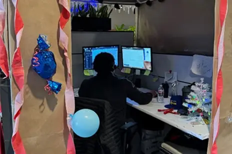 The image depicts staff working in office cubicles at Commercial Funding Partners, decorated for Christmas.