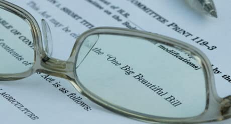 Reading glasses focusing on the text 'One Big Beautiful Bill' on a printed legislative or legal document.