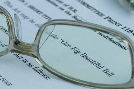 Reading glasses focusing on the text 'One Big Beautiful Bill' on a printed legislative or legal document.