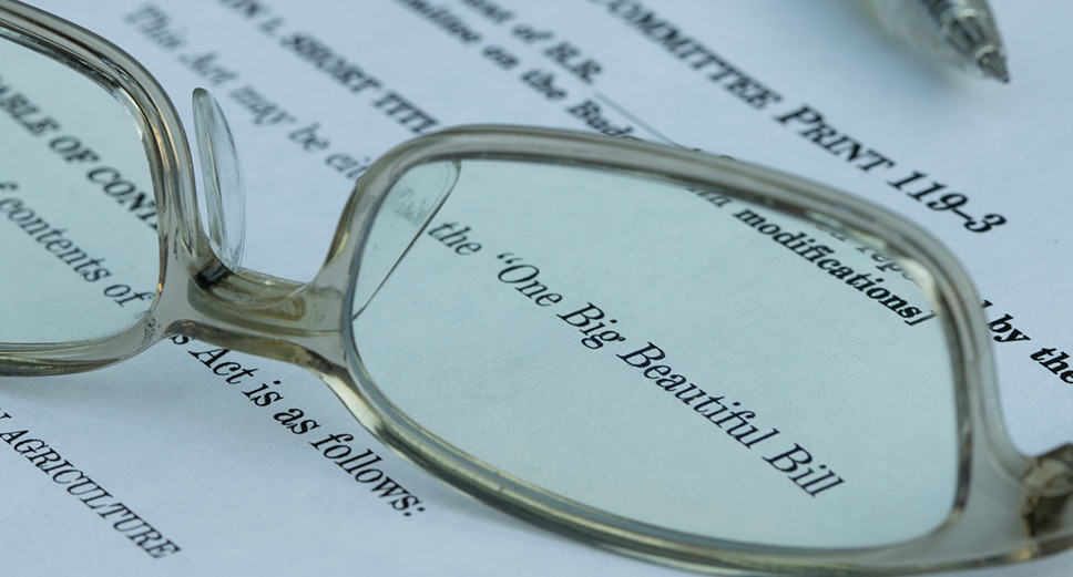 Reading glasses focusing on the text 'One Big Beautiful Bill' on a printed legislative or legal document.